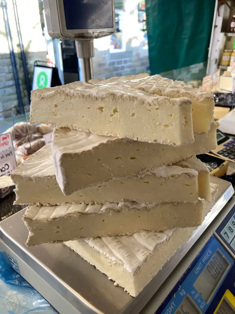 Brie and cheese displayed at a market stall
